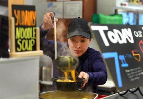 Boston-4/08/16- The Boston Public Market has been open for a while and was busy during the noon lunchtime. Audrey Yap(cq) co-owner of noodle Lab serves up a dish. Boston Globe staff photo by John Tlumacki (business)
