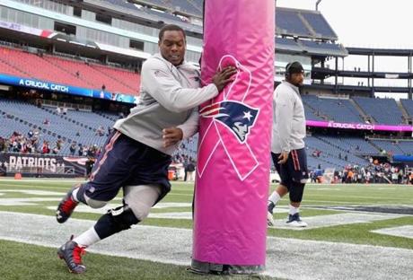 FOXBORO, MA - OCTOBER 25: Dominique Easley #99 of the New England Patriots hits a goal post with a breast cancer awareness logo before a game against the New York Jets at Gillette Stadium on October 25, 2015 in Foxboro, Massachusetts. (Photo by Jim Rogash/Getty Images)
