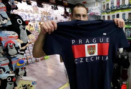 A vendor displays a t-shirt with a sign Czechia in a souvenir gift shop in central Prague, Czech Republic.
