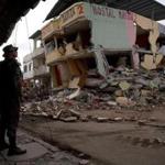 An air force soldier stands guard in front of buildings collapsed by an earthquake in Manta, Ecuador, Monday, April 18, 2016. A Saturday night quake left a trail of ruin along Ecuador?s Pacific Ocean coast. Hundreds died and thousands are homeless. (AP Photo/Rodrigo Abd)
