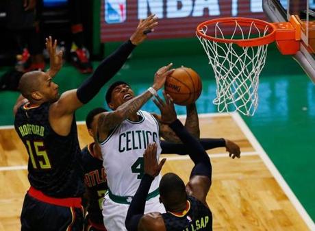 Boston, MA - 4/22/2016 - Boston Celtics Isaiah Thomas (C) drives to the basket between Atlanta Hawks Al Horford (L) and Paul Millsap (R) during the second quarter at TD Garden in their third playoff game in Boston, MA April 22, 2016. Jessica Rinaldi/Globe Staff Topic: Celtics Reporter: 
