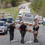 Authorities set up road blocks at the perimeter of a crime scene, in Pike County, Ohio Friday.
