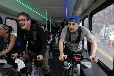 Reporters David Filipov (left) and Steve Annear work out on the BikeBus. 
