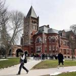 In this photo taken Wednesday April 6, 2016 students walk past the historic Thompson Hall at the University of New Hampshire in Durham, N.H. The water system serving the University is among more than two dozen in New Hampshire that have exceeded the federal lead standard at least once in the last three years. (AP Photo/Jim Cole)