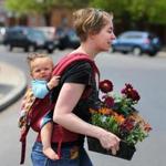 Carolyn Salvi of Somerville carried her daughter, Mohini, and some flowers that she got for herself for Mother?s Day last year.
