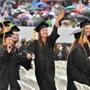 A group of University of Massachusetts graduates wave as they walk to their seats at the start of commencement Friday, May 6, 2016, at McGuirk Stadium in Amherst, Mass. (Jerrey Roberts/The Daily Hampshire Gazette via AP) MANDATORY CREDIT 