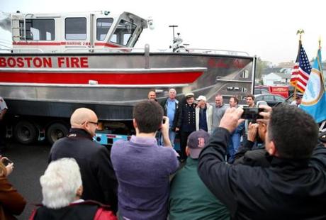 The Rev. Dan Mahoney posed for pictures with the new vessel, which will be used in rescues and to fight fires.
