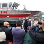 The Rev. Dan Mahoney posed for pictures with the new vessel, which will be used in rescues and to fight fires.
