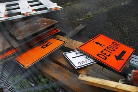 Signs were placed in a pile at a Green Line extension construction site in Gilman Square in Somerville. On Monday, state transportation officials will receive a report on how to scale back the project dramatically.
Estimates that showed the extension could cost $1 billion more than projected halted the project.

