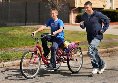 Dillon Doyle, 13, rode his bike down his street after its return as brother Matt ran alongside. 
