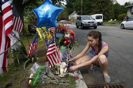 Shannon Courtney, 14, of Auburn, placed a pinwheel at a makeshift memorial where Officer Ronald Tarentino was killed.

