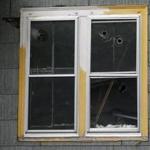 Bullet holes riddled a window of the Oxford house where Jorge Zambrano was killed.