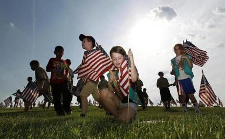 Throngs of scouts rush to place thousands of flags on veteran's graves at Brig. Gen. William C. Doyle Veterans Memorial Cemetery in honor of Memorial Day, Friday, May 27, 2016, in Wrightstown N.J. (AP Photo/Mel Evans)
