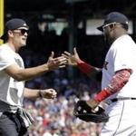 New England Patriots quarterback Tom Brady, left, greets Boston Red Sox's David Ortiz after throwing the ceremonial first pitch prior to the home opener baseball game between the Boston Red Sox and the Washington Nationals at Fenway Park in Boston, Monday, April 13, 2015. (AP Photo/Elise Amendola)