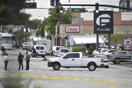 Police stood near the area of the mass shooting at the Pulse nightclub on in Orlando on Sunday.
