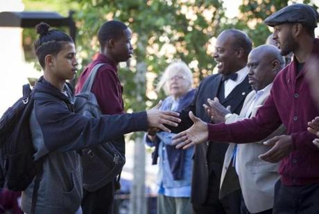 6/13/16 - Dorchester, MA - Jeremiah Burke High School - Student Kevin Pires, cq, left, 15, of Dorchester, was greeted by men of color from Boston and surrounding communities as he arrived at school on Monday morning, June 13, 2016. The men were gathered to show support, encouragement, and examples of positive role models in the wake of a tragic loss within the school community. The welcome was organized jointly by the Mayor's Office of Public Safety Initiatives and Boston Public Schools. Topic: 14burke. Story by Jeremy Fox/Globe Staff. Photo by Dina Rudick/Globe Staff
