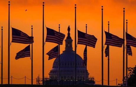 ORLANDO SLIDER 2 Flags fly at half-staff around the Washington Monument at daybreak in Washington with the US Capitol in the background Monday, June 13, 2016. President Barack Obama ordered flags lowered to half-staff to honor the victims of the Orlando nightclub shootings. (AP Photo/J. David Ake.)
