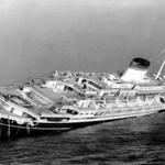 FILE - In this July 26, 1956 file photo, the Italian luxury liner Andrea Doria keels far over to starboard before sinking 225 feet to the bottom of the Atlantic 45 miles off Nantucket Island, Mass. Nearly six decades after the Andrea Doria slammed into another ocean liner, killing 46 people, explorers are preparing to do what 16 others have lost their lives attempting: get a fresh glimpse of the wreckage on the sea floor. Everett, Washington-based OceanGate will use a five-person submarine in June 2016 to get high-definition video and 3-D sonar images of the shipwreck. (AP Photo/John Rooney, File)