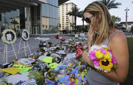 Amy Semesco wipes a tear as she pays tribute, Tuesday, June 14, 2016, in Orlando, Fla., at a growing memorial at the The Dr. Phillips Center for the victims of the mass shooting Sunday at the Pulse Nightclub. (AP Photo/Alan Diaz)
