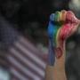 A fist is raised near an American flag at a vigil in Los Angeles for the mass shooting in Orlando.