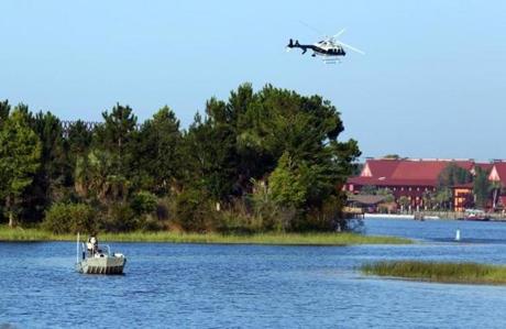 Florida Fish and Wildlife and an Orange County Sheriffs helicopter search for a young boy early Wednesday, June 15, 2016, after the boy was dragged into the water Tuesday night by an alligator near Disney's upscale Grand Floridian Resort & Spa in Lake Buena Vista, Fla. (Red Huber/Orlando Sentinel via AP) MAGS OUT; NO SALES; MANDATORY CREDIT 

