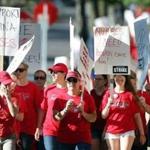 Thousands of nurses walk around Abbott Northwestern hospital on the first day of a strike Sunday, June 19, 2016, in Minneapolis, Minn. About 4,800 nurses at five Minneapolis-area hospitals, all operated by Allina Health, began a weeklong strike Sunday over a contract impasse. (Jerry Holt /Star Tribune via AP)