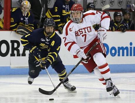 Boston MA 1/29/16 Boston University freshman Charlie McAvoy skates with the puck in front of Merrimack College Marc Biega during third period action at Agganis Arena on Friday January 29, 2016. (Matthew J. Lee/Globe staff) Topic: Reporter: 
