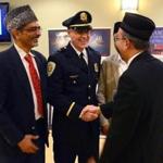 The Ahmadiyya Muslim Community of Boston hosted an Iftar dinner with a reception, guest speakers, and an introduction to Islam at the Sharon Community Center. From left to right, Dr. Amer Malik, Sharon police Lieutenant Donald Brewer, and Nasir Rana greet one another.