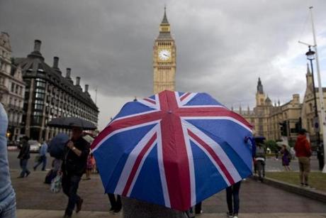 A pedestrian found shleter from the rain beneath a Union flag-themed umbrella as they walk near the Big Ben clock face  in London.
