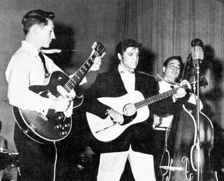 Elvis Presley was flanked by Scotty Moore on guitar and Bill Black on the stand-up bass. 

