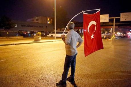 ANKARA, TURKEY - JULY 16: A man hold a Turkish flag stand in front of the Turkish Army?s Headquarters on the main street of Ankara, July 16, 2016, Turkey. Istanbul?s bridges across the Bosphorus, the strait separating the European and Asian sides of the city, had been closed to traffic.Turkish President Recep Tayyip Erdogan has denounced an army coup attempt, that has left at least 90 dead 1154 injured in overnight clashes in Istanbul and Ankara. (Photo by )
