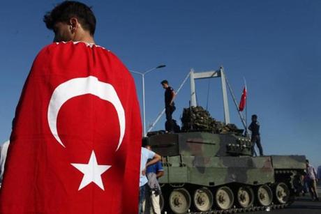 ISTANBUL, TURKEY - JULY 16: People gather for celebration around Turkish police officers, loyal to the government, standing atop tanks abandoned by Turkish army officers, against a backdrop of Istanbul's iconic  Bosphorus Bridge in Istanbul, July 16, 2016, Turkey. Istanbul's bridges across the Bosphorus, the strait separating the European and Asian sides of the city, had been closed to traffic.Turkish President Recep Tayyip Erdogan has denounced an army coup attempt, that has left atleast 90 dead 1154 injured in overnight clashes in Istanbul and Ankara. (Photo by Burak Kara/Getty Images)
