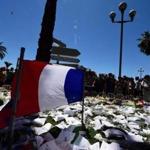A French flag is seen as people gather to pay tribute at a makeshift memorial in Nice on July 16, 2016, two days after a deadly attack on the Promenade des Anglais killed 84 people during a fireworks display. The Islamic State group claimed responsibility on July 16, 2016 for an attack in which a Tunisian drove a truck through a crowd in Nice, killing 84, prompting hard questions in France over security failures. / AFP PHOTO / GIUSEPPE CACACEGIUSEPPE CACACE/AFP/Getty Images
