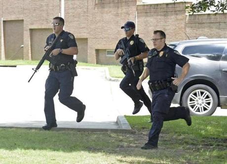 Baton Rouge Police run from the emergency room ramp as a man is taken into custody after a gun was found in his vehicle near the entrance of Our Lady Of The Lake Medical Center, Sunday, July 17, 2016, in Baton Rouge, La.
