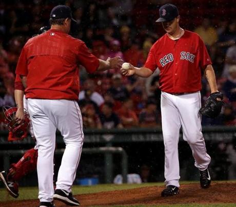 Boston, MA - 7/01/2016 - (6th inning) Boston Red Sox starting pitcher Steven Wright (35) hands off the ball to Boston Red Sox manager John Farrell (53) after being received during the sixth inning. The Boston Red Sox take on the Los Angeles Angels in Game 1of a 3 game series at Fenway Park. - (Barry Chin/Globe Staff), Section: Sports, Reporter: Peter Abraham, Topic: 02Red Sox-Angels, LOID: 8.2.3506516646.
