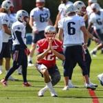 Quarterback Tom Brady looked like he was doing a yoga stance as he loosens up during the first day of Patriots training camp.
