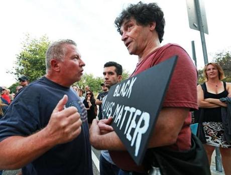 Tom Griffin of Revere (left), who supports police officers? effort, had a disagreement with Roy Pardi (right), who showed up carrying a sign that read 