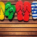 Multicolor flip-flops on wooden background. Summer family vacation concept; Shutterstock ID 269437022; PO: oped