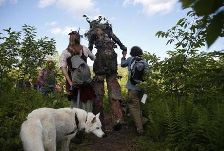 Mt. Tabor, VT - 7/3/2016 - Rainbow Family members hold hands with a man dressed as an Ent as they walk into a meadow during a Rainbow Gathering in Mt. Tabor, VT, July 3, 2016.(Jessica Rinaldi/Globe Staff) 
