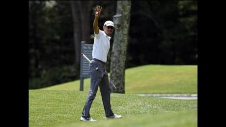 President Barack Obama waves as he plays plays golf on the first hole at Farm Neck Golf Club in Oak Bluffs, Mass., on Martha's Vineyard, Saturday, Aug. 15, 2015. Obama and his family vacation every August on Martha's Vineyard, and he's been spending most of this year's two-week trip on the golf course, at the beach and dining at the island's upscale restaurants.(AP Photo/Susan Walsh)
