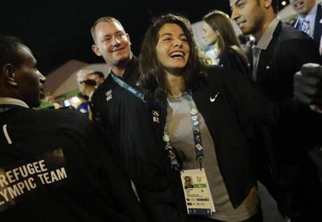 Refugee Olympic Team's Yusra Mardini, center, smiles during a welcome ceremony held at the Olympic village ahead of the 2016 Summer Olympics in Rio de Janeiro, Brazil, Wednesday, Aug. 3, 2016. (AP Photo/Jae C. Hong)
