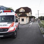 In this Aug. 13, 2016 picture a police car stands at the train station following an attack onboard, a train in Salez, Switzerland. A 34-year-old woman died Sunday from wounds suffered after a man attacked her and four others with a knife and a burning liquid aboard a crowded train in Switzerland. Police are still searching for a motive but said there's no indication the suspect, identified only as a 27-year-old Swiss man from a neighboring region, had ties to extremist groups. (Gian Ehrenzeller/Keystone via AP)