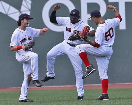 Red Sox outfielders (from left) Andrew Benintendi, Jackie Bradley Jr., and Mookie Betts celebrated their 16-2 victory over the Diamondbacks at Fenway Park on Sunday. 
