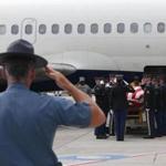 A state trooper saluted as the body of Korean War prisoner of war Ronald M. Sparks was unloaded from a plane at Logan International Airport on Tuesday.