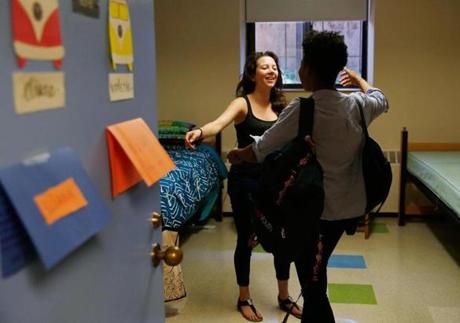 Eliana Phillips (left), from California, hugged her new roommate, Valérie Pierre-Louis, from New York, at Brandeis University Sunday. 

