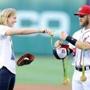 WASHINGTON, DC - AUGUST 24: Katie Ledecky hands her Olympic medals to Bryce Harper #34 before throwing out the opening pitch before the game between the Baltimore Orioles and the Washington Nationals at Nationals Park on August 24, 2016 in Washington, DC. (Photo by Greg Fiume/Getty Images)