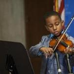Boston, MA - 8/24/2016 - Five-year-old Ashton A. Antoine plays his violin before signing his book 