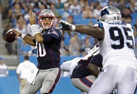 New England Patriots' Jimmy Garoppolo (10) looks to pass under pressure from Carolina Panthers' Charles Johnson (95) during the second half of a preseason NFL football game in Charlotte, N.C., Friday, Aug. 26, 2016. (AP Photo/Bob Leverone)
