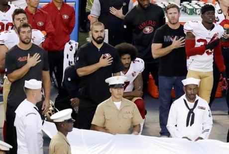 San Francisco 49ers quarterback Colin Kaepernick, middle, knelt during the national anthem before the team's NFL preseason football game against the San Diego Chargers on Thursday. 
