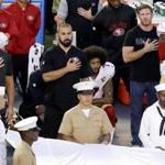 San Francisco 49ers quarterback Colin Kaepernick, middle, knelt during the national anthem before the team's NFL preseason football game against the San Diego Chargers on Thursday. 